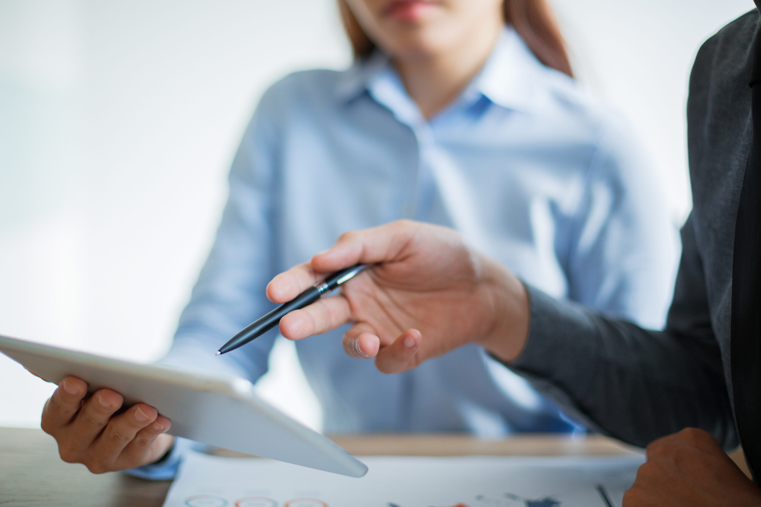 Unternehmensberatung – Team diskutiert Informationen am Tablet